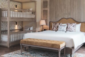 A bedroom with a large bed, a bench, a nightstand, and a wall-mounted shelf with multiple beds. - Mercure Dalat Resort (Lam Vien - Da Lat)