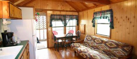 Un chalet confortable avec un intérieur en bois, un coin repas et un canapé.