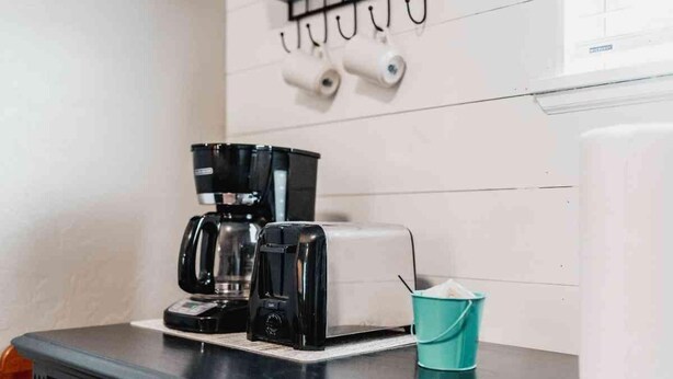 A kitchenette with a coffee maker, toaster, and a teal cup holder. - Lake Texoma Quad-plex (Mead)