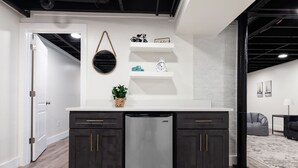 A modern kitchen with dark cabinets, a stainless steel refrigerator, and a white countertop. - Crestwood Contemporary - Minutes to Downtown! (Birmingham)