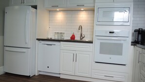 A kitchen with white cabinetry, a built-in microwave, and a dishwasher.