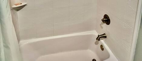 A bathroom with a bathtub, a shower, and a toilet.