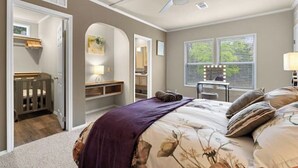 A bedroom with a bed, a vanity with a mirror, a desk with a lamp, and a window with blinds. - 8 acres Ranch - 2 Homes - Sleeps 16 - Dripping (Dripping Springs)