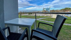 Een balkon met een tafel en twee stoelen, met uitzicht op een parkeerplaats en een waterpark.