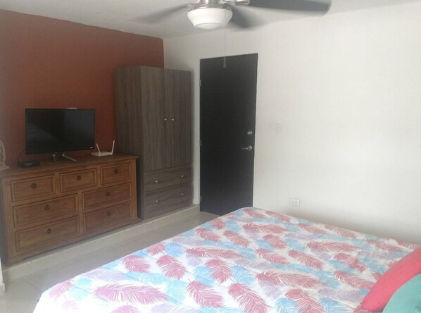 Relax in this inviting bedroom with a comfortable bed, a dresser, and a flat-screen TV.