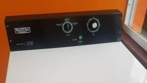 A white Maytag washing machine with a control panel, located in a room with orange walls and a window. - Very clean 1-bedroom Apt. in St. Georges, Grenada (Saint George's)