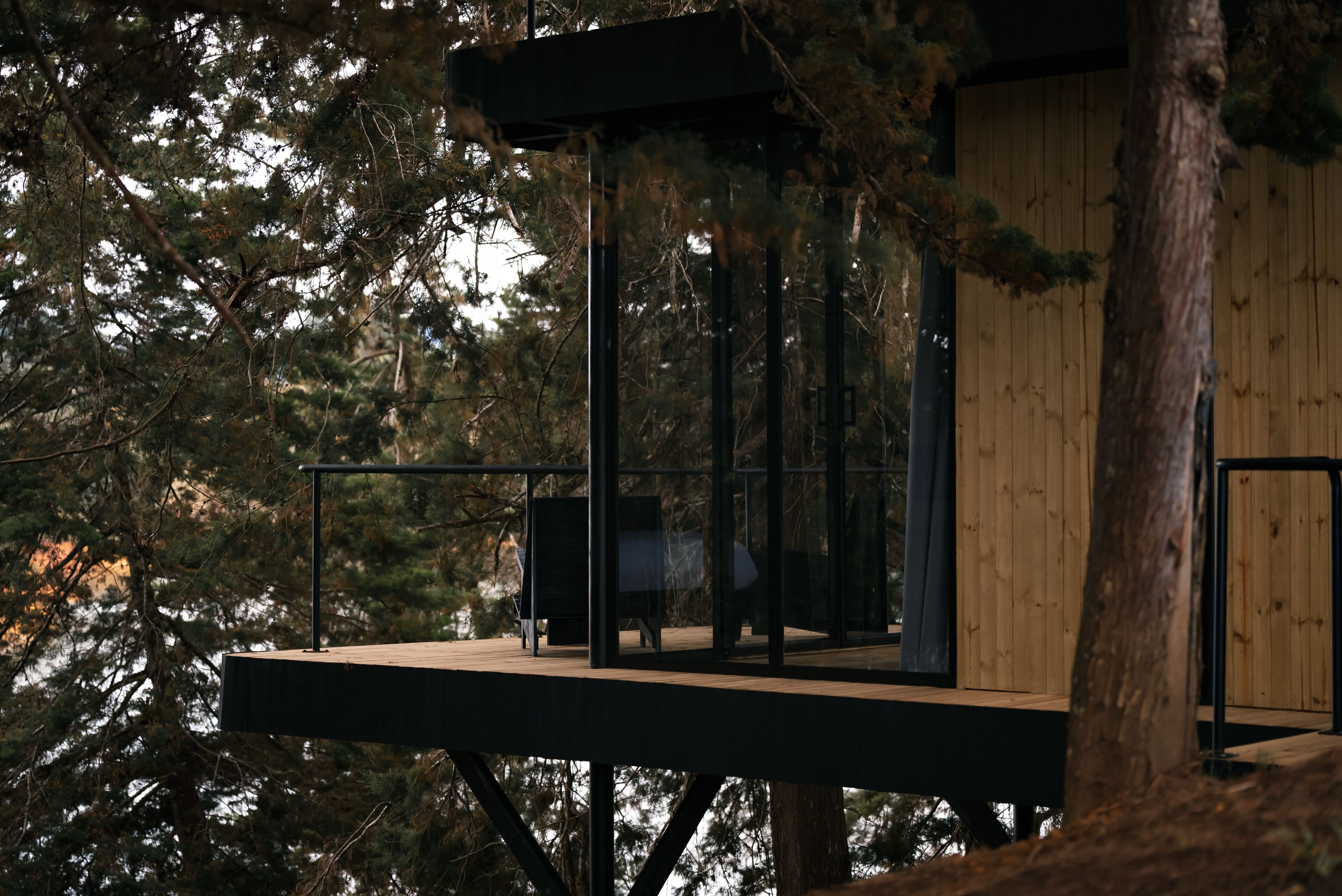 Eine Holzhütte mit Balkon, umgeben von Bäumen.