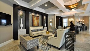 Una sala de estar moderna con un sofá, un sillón, una mesa de centro y un jarrón decorativo.