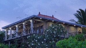 A two-story house with a balcony, surrounded by greenery and a clear sky. - NEW Stunning 3 bed Luxury Balinese Villa with Panoramic Ocean Views and Pool (Bali)