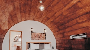 A cozy bedroom with a wooden ceiling, a bed with grey bedding, and a wooden floor. - Finca El Mirador (Valle de Guadalupe)