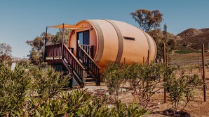 A cylindrical building with a wooden staircase and a balcony. - Finca El Mirador (Valle de Guadalupe)
