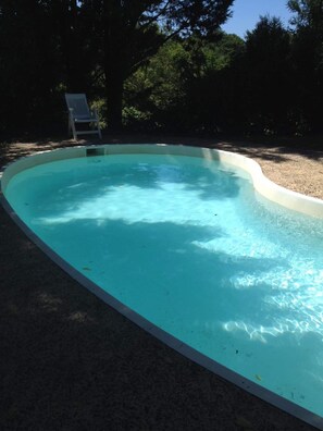 Relax by the pool surrounded by a serene natural setting.