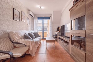 Een moderne woonkamer met een bank, een televisie en een houten kast.