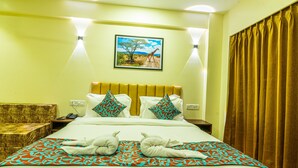 A hotel room with a bed, a headboard, a nightstand, a telephone, a wall-mounted painting, and a window with curtains. - Chinar Wood Resort Dapoli (Dapoli)