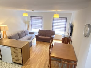 Cozy living space with a kitchenette, dining area, and seating area featuring a sofa and a couch.