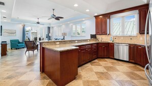 A spacious kitchen with a large island, wooden cabinets, and a dishwasher.