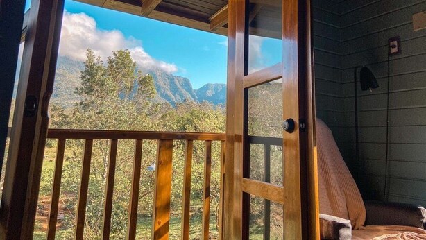 A wooden cabin with a balcony overlooking a mountainous landscape. - Tiny House Garden - Praia Grande - SC (Praia Grande)
