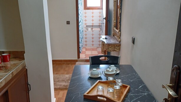 A dining area with a black table, chairs, and a tray with glasses and a teapot. - Belle Vue Studios & Apartments (Ifrane)