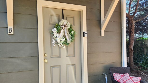 A house entrance with a door, a welcome mat, and a chair with a cushion. - Modern Retro Retreat (McKinleyville)