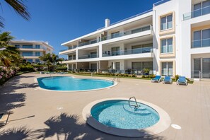 A modern hotel with a pool area, including a large rectangular pool and a smaller hot tub. - CoolHouses Algarve Lagos | Amor à Vida T3 (Lagos)