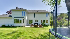 A two-story house with a front porch, a trampoline, and a well-maintained lawn. - Spacious Buffalo Brick Home w/ Backyard! (Buffalo)
