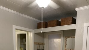 A bedroom with a bed, a wicker chair, a closet, and a mirror on the wall. - Cheerful Cottage Close to the Beach! (Lake Worth)