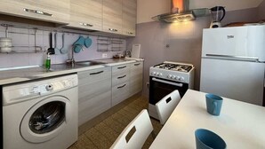 A compact kitchen with a washing machine, stove, and refrigerator. - Apartment few steps from the lake - Larihome A16 (Dongo)