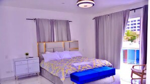 Una camera da letto con un letto, un comodino, una panca blu e una sedia.