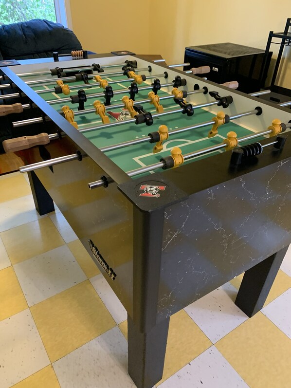 A foosball table with a green playing surface and black and yellow player figures. - Premier Host-Tetonka & Sakatah Lakes Dock, Kayaks, Lakeside Fire Pit & Gameroom (Waterville)