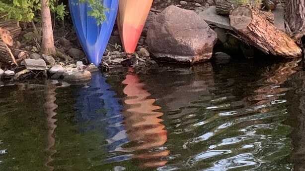 A pond with kayaks and a swing set in the background. - Premier Host-Tetonka & Sakatah Lakes Dock, Kayaks, Lakeside Fire Pit & Gameroom (Waterville)