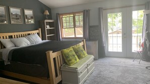 A bedroom with a bed, a nightstand, a dresser, a window, and a door. - Premier Host-Tetonka & Sakatah Lakes Dock, Kayaks, Lakeside Fire Pit & Gameroom (Waterville)