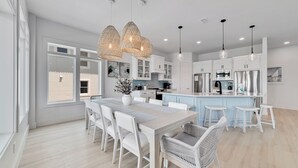 A modern kitchen with white cabinetry, a central island, and pendant lighting. - PRIVATE LUXURY HOUSE, COMMUNITY POOL, WATERFRONT ON LITTLE LAGOON! (Gulf Shores)