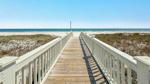 A wooden boardwalk leading to a beach with white railings on both sides. - PRIVATE LUXURY HOUSE, COMMUNITY POOL, WATERFRONT ON LITTLE LAGOON! (Gulf Shores)