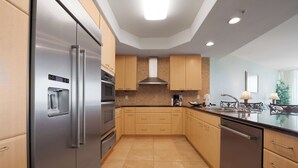 Eine moderne Küche mit Edelstahlgeräten, Holzschränken und Fliesenboden.