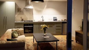 Cozinha moderna com área de jantar, incluindo um sofá, uma mesa de centro com um vaso e um lustre.