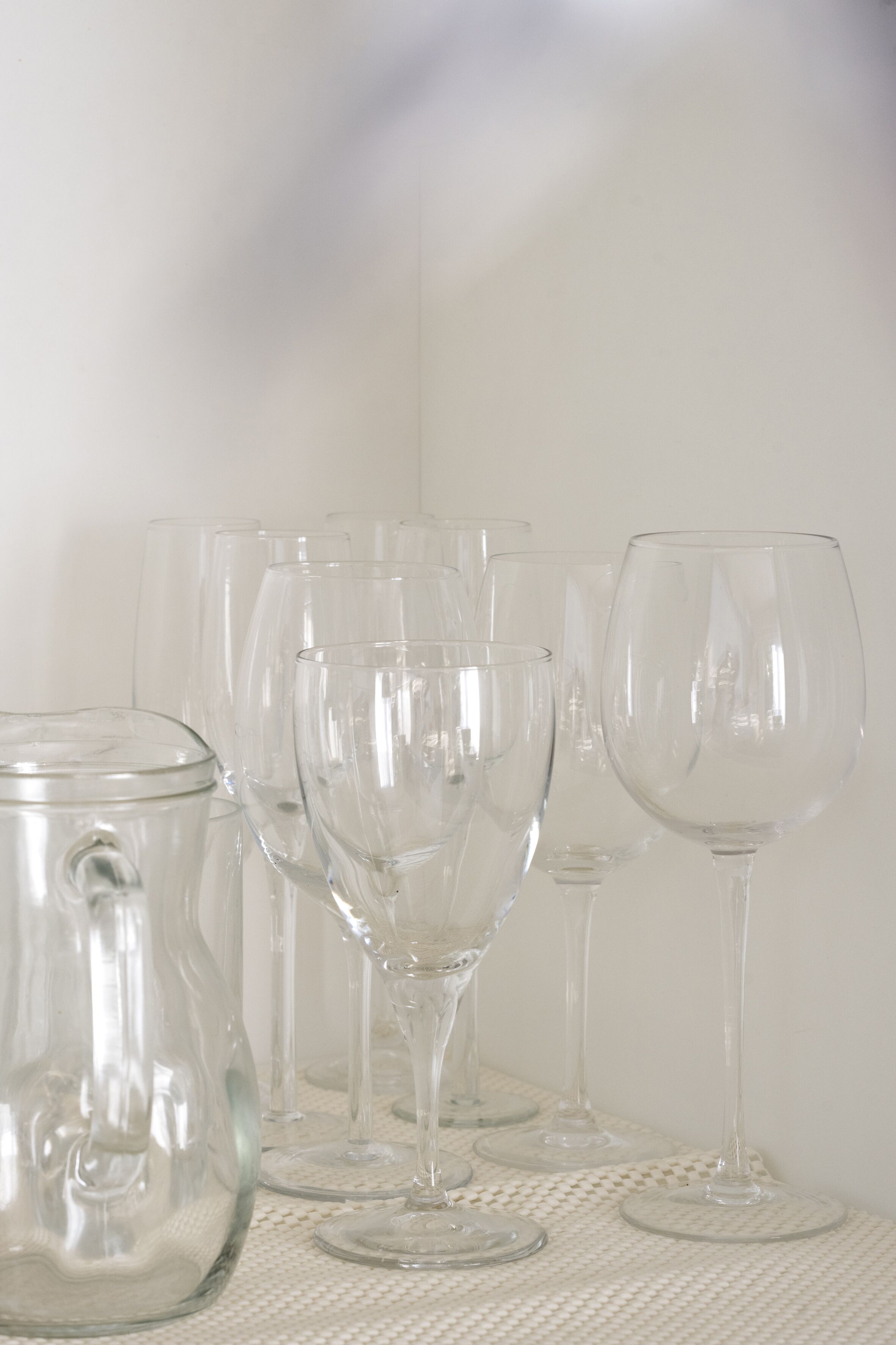 A collection of clear glassware on a textured surface.