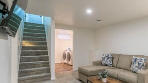 A living room with a staircase, a sofa, and a coffee table.