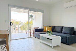 Superior Apartment | Living area | 65-inch Smart TV with digital channels, TV - One on Harris Apartments (Wellington Point)