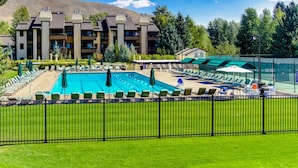 A hotel with a swimming pool, multiple lounge areas, and a mountain backdrop. - Retro 3BD Sun Valley Condo + FREE Resort Amenities! (Sun Valley)