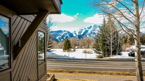 A view from a window overlooking a road with snow-covered mountains in the background. - Retro 3BD Sun Valley Condo + FREE Resort Amenities! (Sun Valley)