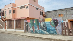 A pink building with a mural of a boat and waves on the side. - San Alejo Zero (Charapoto)