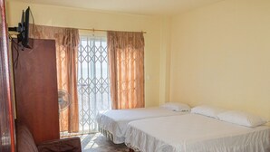A room with two beds, a brown sofa, and a window with curtains. - San Alejo Zero (Charapoto)