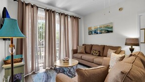 A living room with a sofa, a round coffee table, and a lamp.