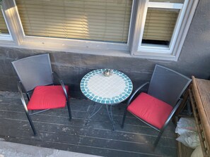 Sit and enjoy the view from this cozy outdoor seating area with a round table and two comfortable chairs.