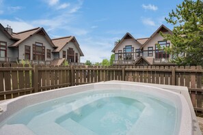 A residential area with a swimming pool, wooden fences, and houses with gabled roofs. - Large Bedroom Suites - Comm Hot Tub - On Ski Bus Line (Steamboat Springs)
