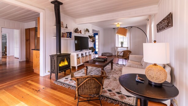 Un salón amplio con chimenea, televisor y asientos cómodos.