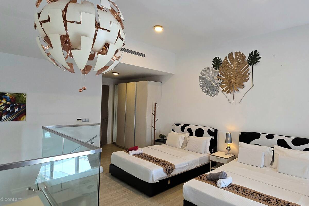 Une chambre d’hôtel moderne avec deux lits, une rambarde en verre, un luminaire décoratif au plafond et une œuvre d’art murale.