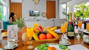 Een eetgedeelte met een fruit- en sapbuffet, een fles Moët & Chandon champagne en een menukaart.