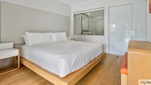 Un dormitorio moderno con una cama grande, una mesita de noche y un armario.