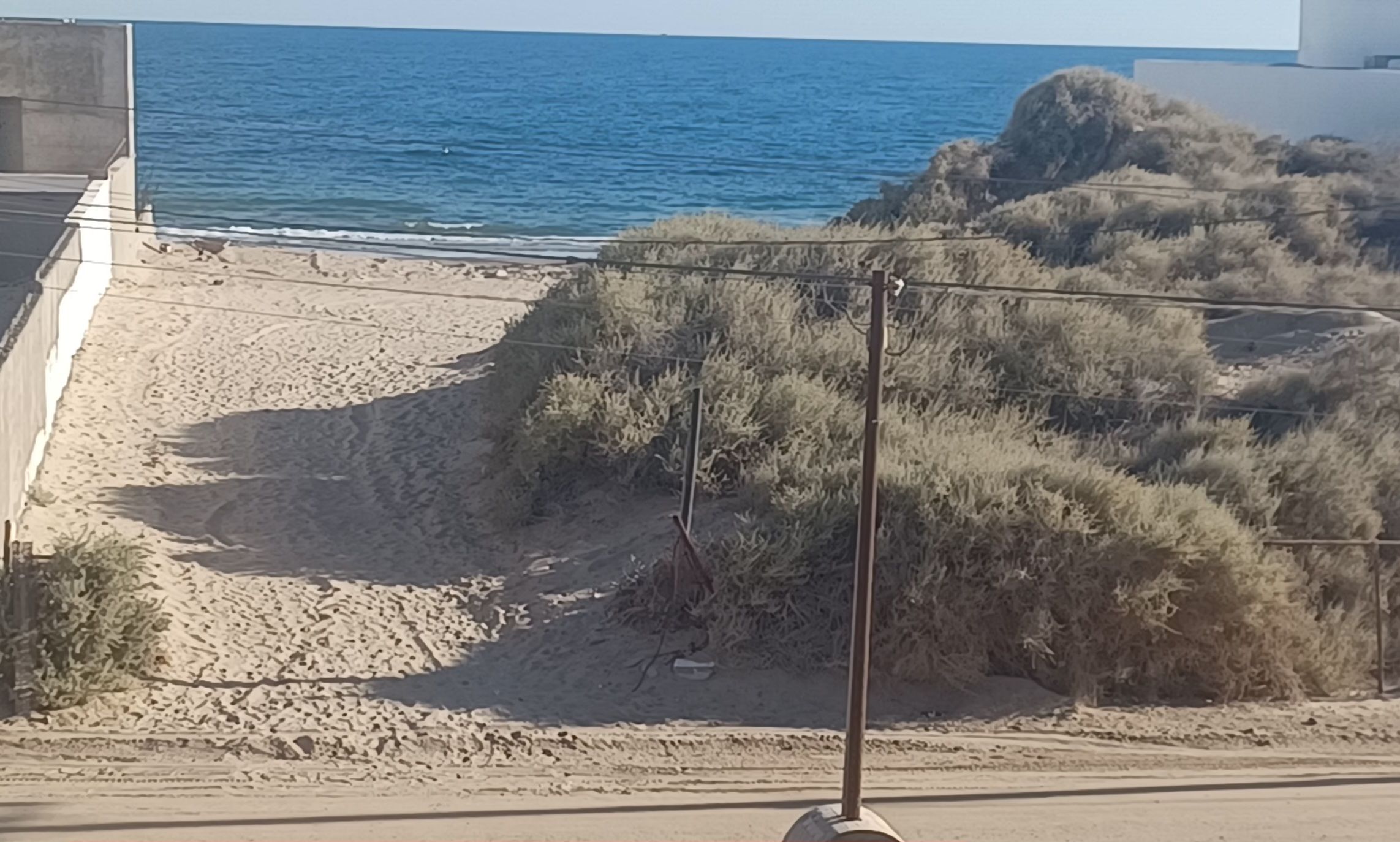 A beach with a sign indicating proximity to a beach.